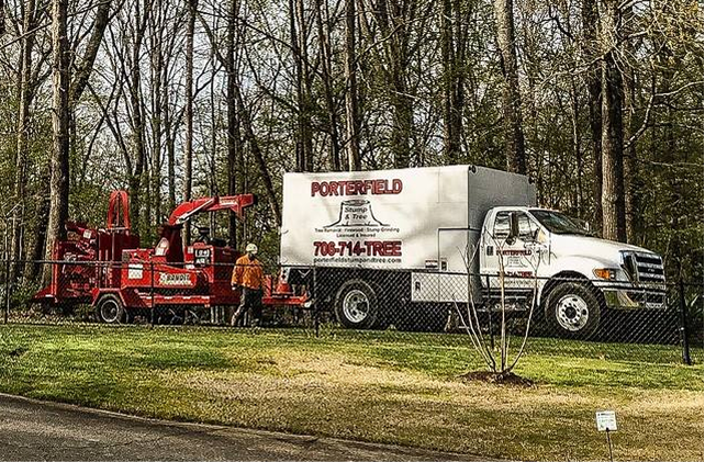 A Porterfield Stump and Tree truck outside a wooded area in Apalachee, GA